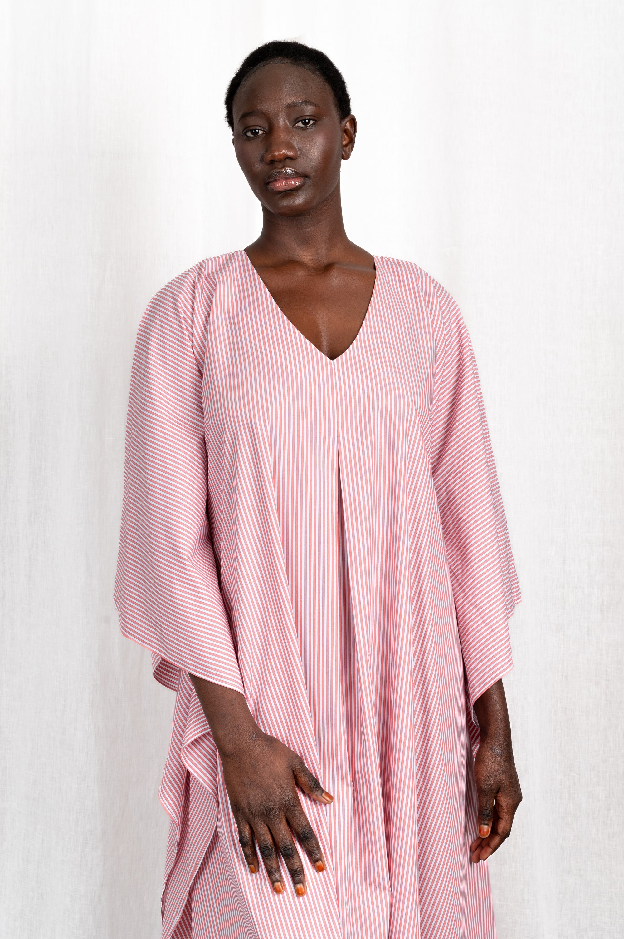Modèle portant la robe Nia rose en coton et rayures roses, vue de portrait #couleur_rose