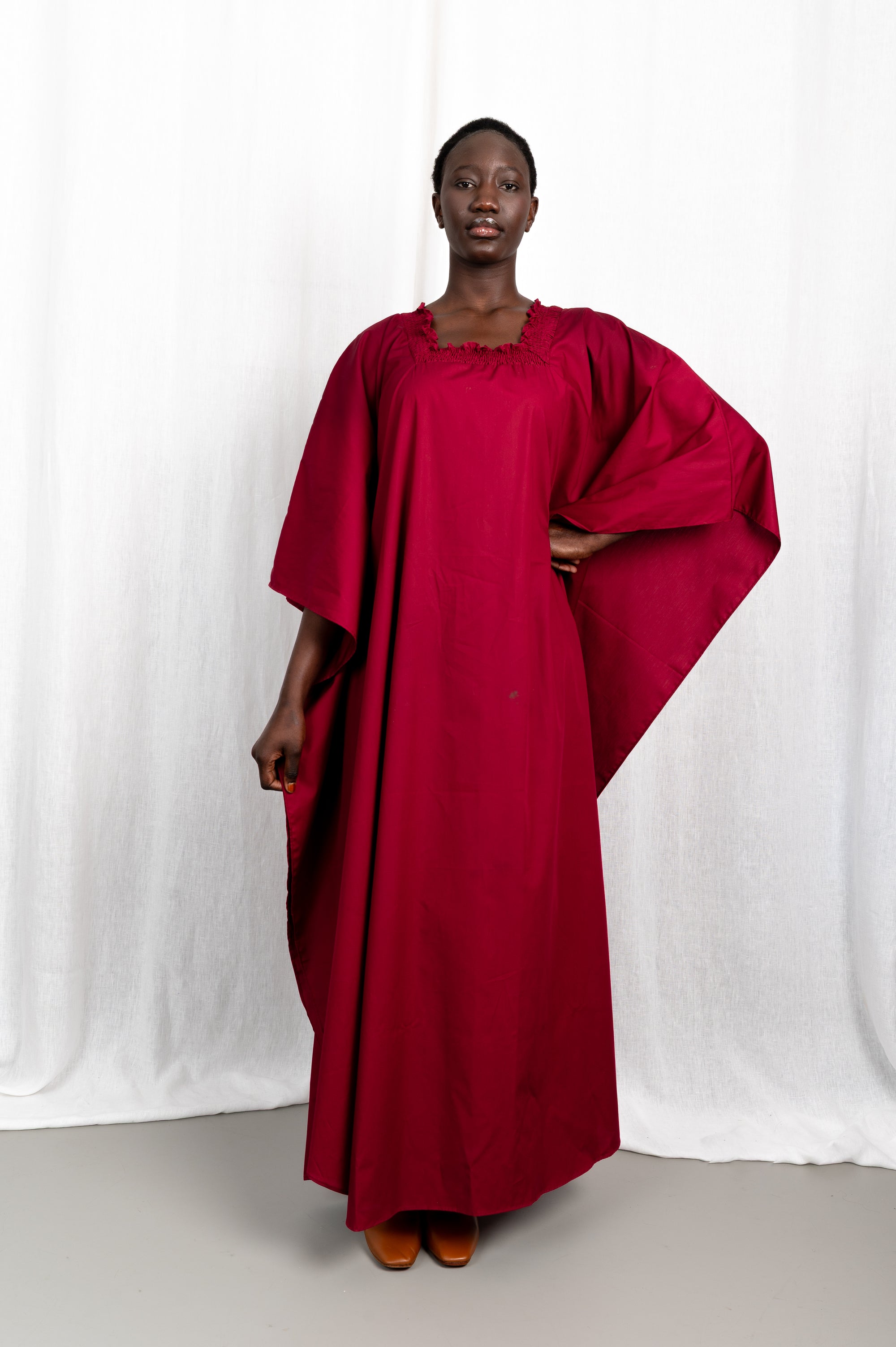 Modèle portant la robe Sira couleur cerise au col carré froncé, vue de face #couleur_cerise