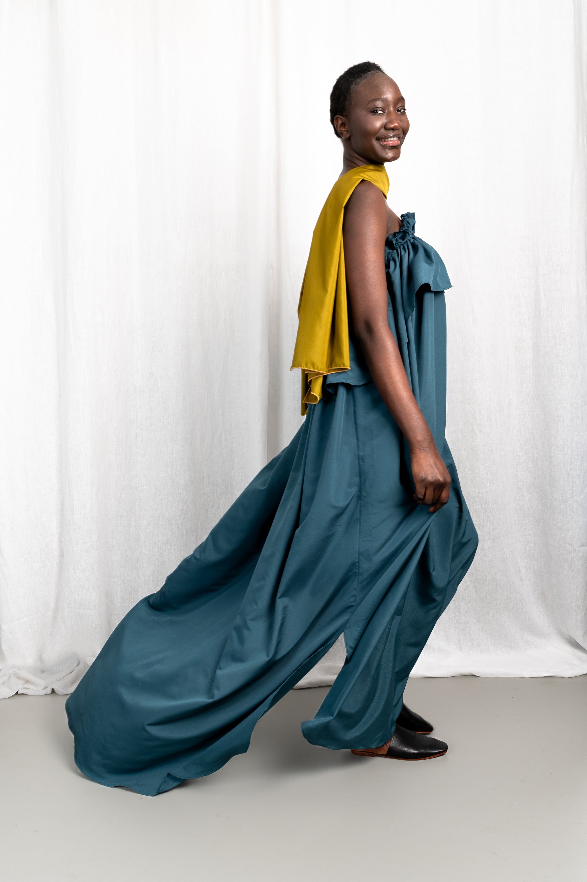 Modèle portant la robe Tamït en crêpe de Chine satiné, vue en mouvement #couleur_bleu vert profond