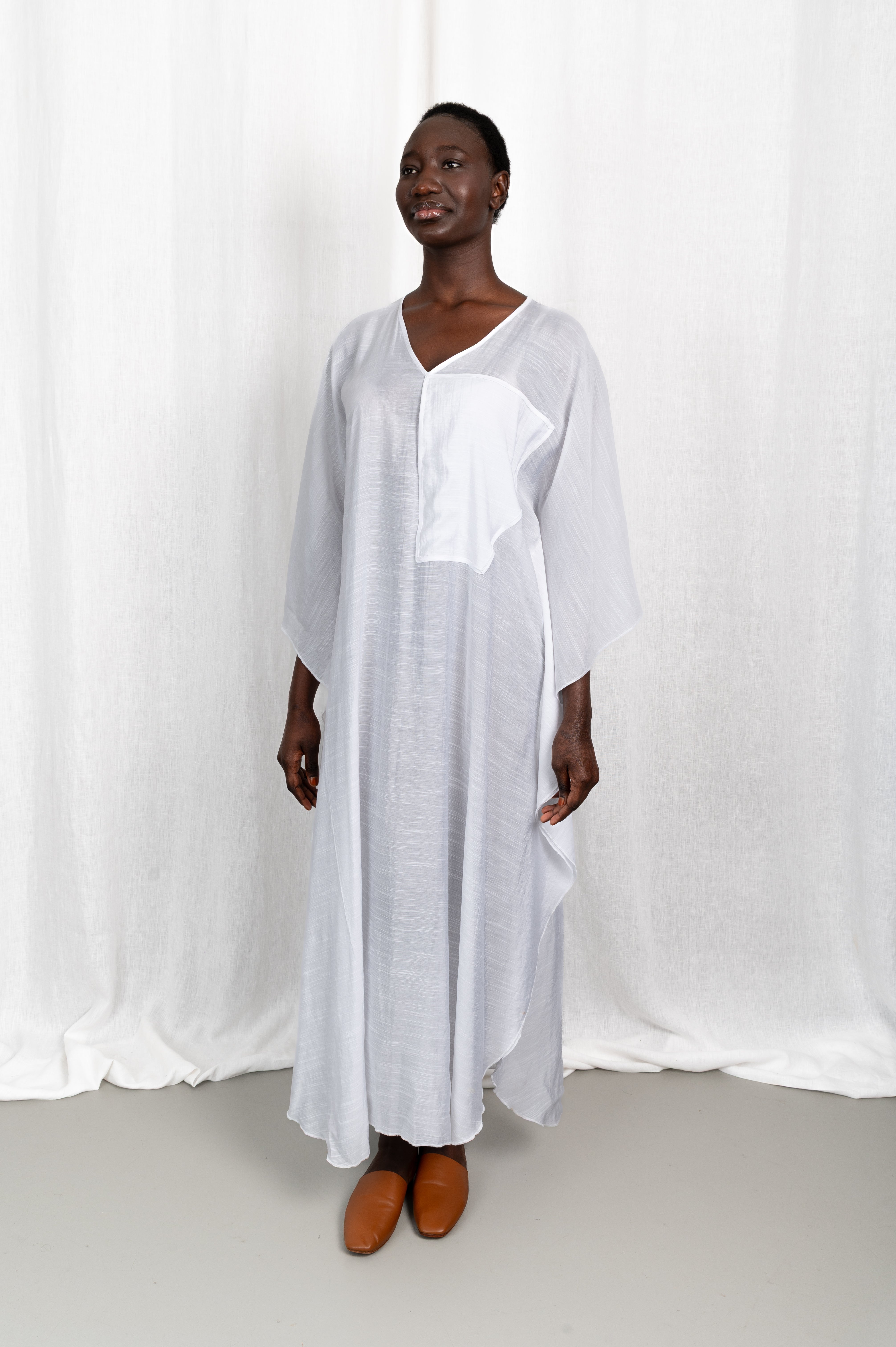 Modèle portant la robe Maali en voile de coton blanc, vue de face
