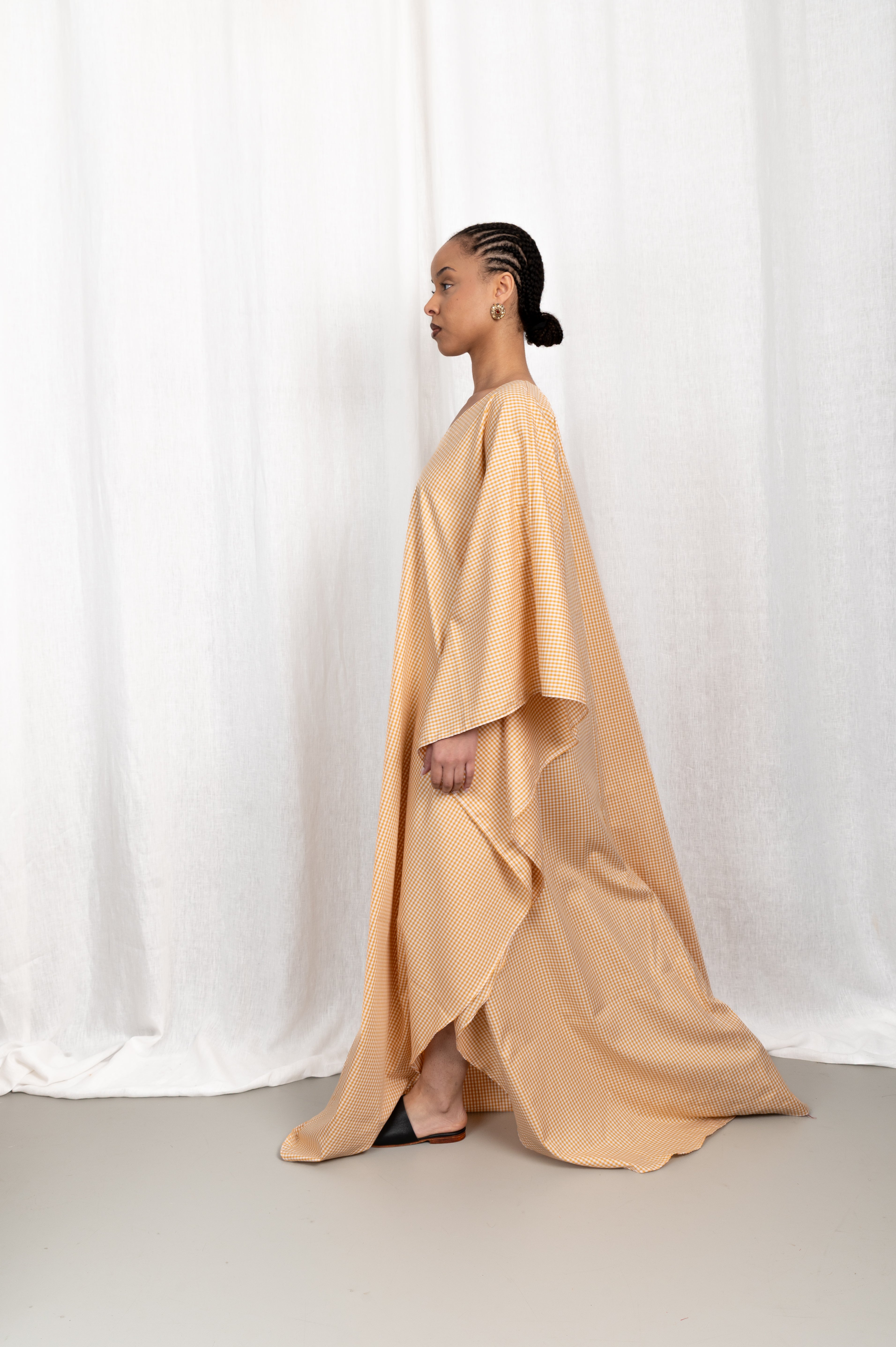 Modèle portant la robe Nia Vichy Jaune en coton ample, vue en mouvement #couleur_jaune vichy